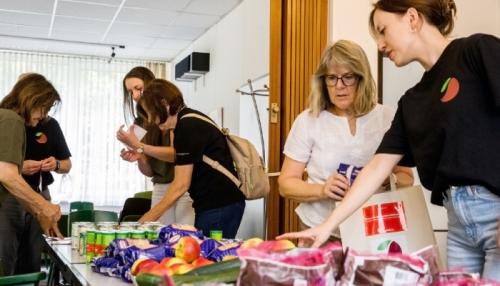 Das Obstkäppchen-Team mit ehrenamtlichen Helferinnen und Helfern beim Packen der Lebensmitteltüten. Foto: Roland Meurer